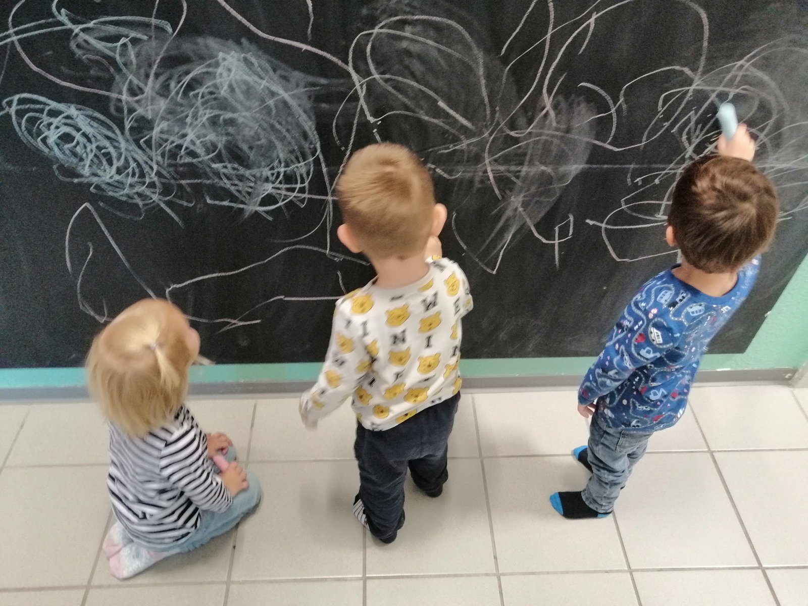 Kinder beim Malen an einer Tafel
