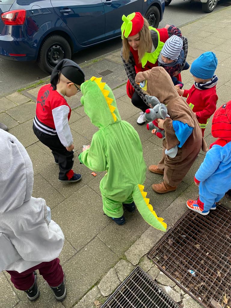 Kinder in bunten Kostümen vor einem Gebäude